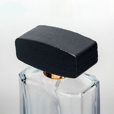 Botella de perfume de cristal vacía con el casquillo negro de madera del collarwith del espray del casquillo y de la bomba
