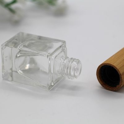 el casquillo de bambú de la botella cuadrada del esmalte de uñas compone la botella vacía cosmética de la botella de cristal