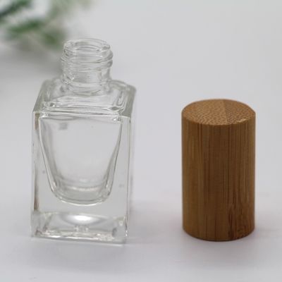 el casquillo de bambú de la botella cuadrada del esmalte de uñas compone la botella vacía cosmética de la botella de cristal